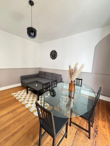 une salle à manger avec une table et des chaises en verre dans l'établissement Soh Rent Appartement 3 proche gare et Centre de Strasbourg TV Wifi - Balcon, à Strasbourg