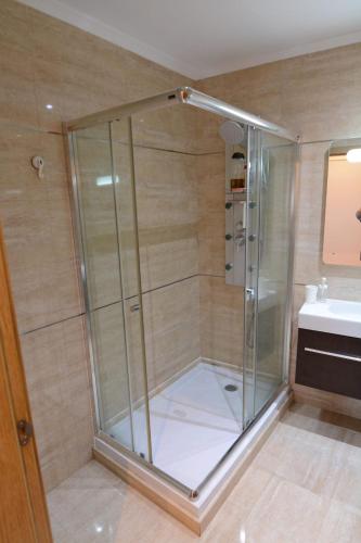 a glass shower in a bathroom with a sink at Algarve 360º Experience in Loulé