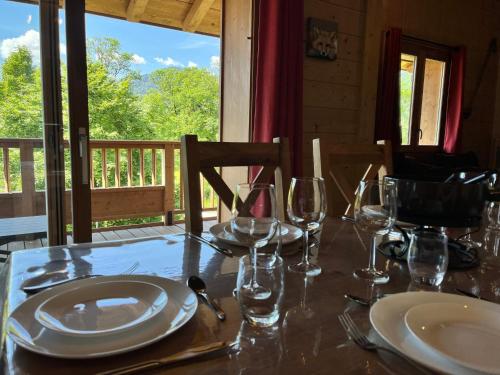 une table avec des assiettes et des verres à vin sur un porche dans l'établissement Superbe Duplex au Pied du Grand Massif, 3 Chambres, WiFi, Parking - FR-1-624-136, à Samoëns