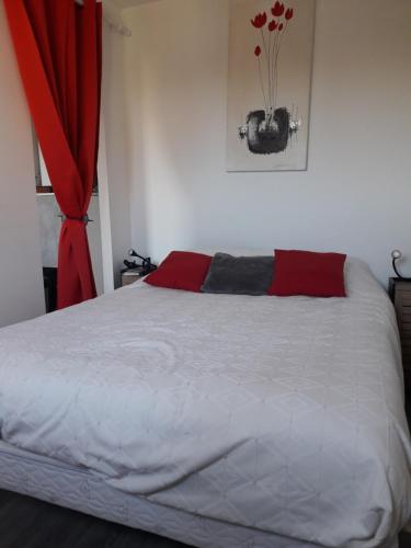 - une chambre avec un lit blanc et un rideau rouge dans l'établissement La Brigantine, au Cap d'Agde