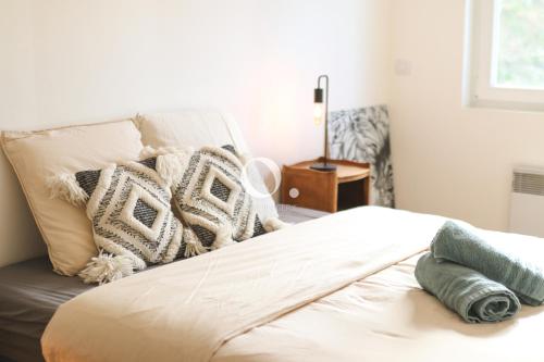 un lit avec des oreillers dessus dans une chambre dans l'établissement COC - Villa L'Idéal, à Hervelinghen