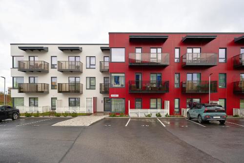 a red and white apartment building with a parking lot at Kristalli 8-2 apartment in Tartu