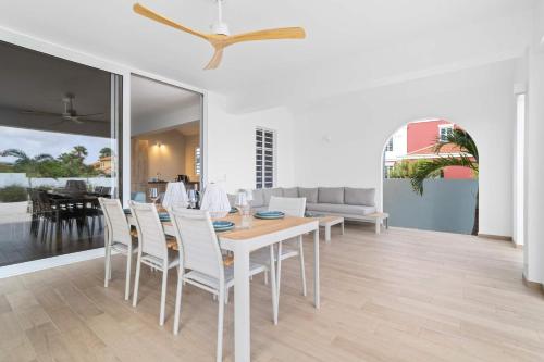 a dining room with a table and white chairs at Casa Enjoy on the water of the Laguna Marina in Kralendijk