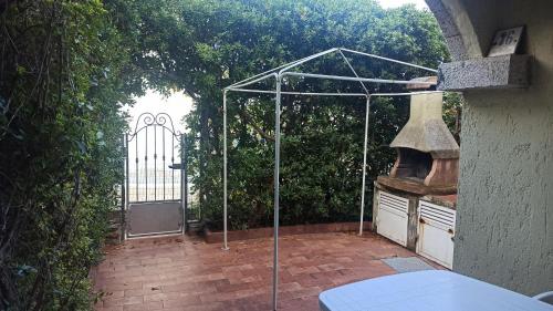 an open gate to a patio with a grill at Casa Maggy in Budoni