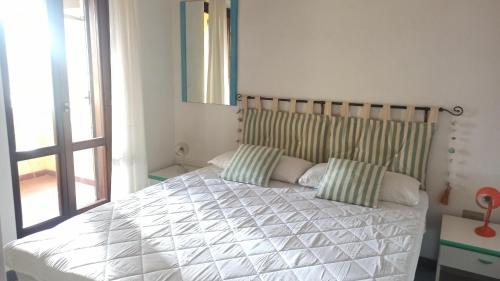 a bedroom with a large bed with two pillows at Casa Maggy in Budoni