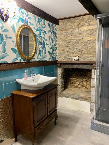 a bathroom with a sink and a fireplace at La maison d'en haut in Josselin