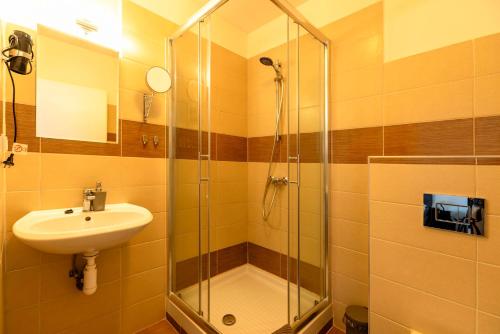 a bathroom with a sink and a shower at Restaurace Hotel Praha in Nižbor