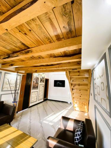 a living room with wooden ceilings and leather furniture at Republika Central Hotel & Resort in Abbottābād