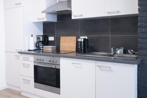 a white kitchen with a sink and a stove at Apartment in Lüneburg, 2 Zimmer, Küche, 80 qm in Lüneburg
