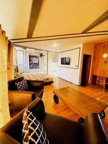 a living room with couches and a coffee table at Republika Central Hotel & Resort in Abbottābād