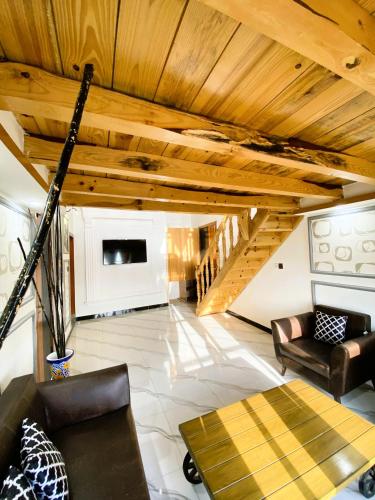 a living room with a wooden ceiling and a couch at Republika Central Hotel & Resort in Abbottābād
