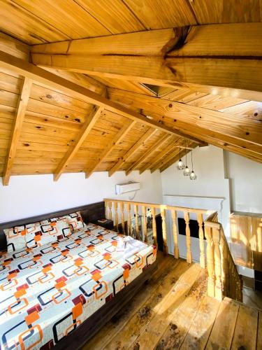 a bed in a room with wooden ceilings at Republika Central Hotel & Resort in Abbottābād