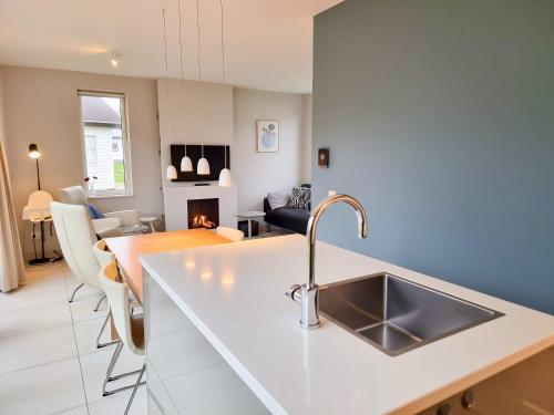 a kitchen with a sink and a living room at Vakantiehuis aan de duinen van Vlissingen VL22 in Vlissingen