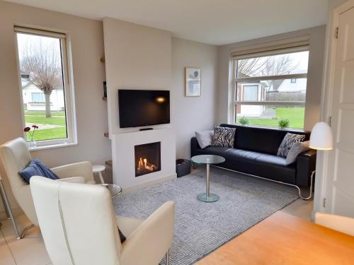 a living room with a couch and a fireplace at Vakantiehuis aan de duinen van Vlissingen VL22 in Vlissingen