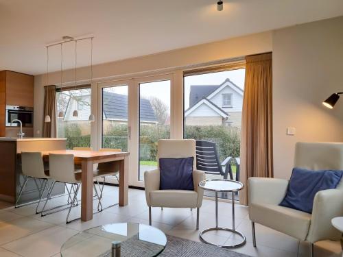 a kitchen and living room with a table and chairs at Vakantiehuis aan de duinen van Vlissingen VL22 in Vlissingen