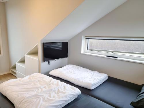 a bedroom with a bed and a tv in it at Vakantiehuis aan de duinen van Vlissingen VL22 in Vlissingen