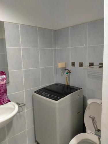 une petite salle de bain avec toilettes et lavabo dans l'établissement Sea Residences Ace, à Manille