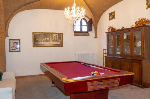 a living room with a pool table and a chandelier at Villa Cresci con piscina in Sassetta
