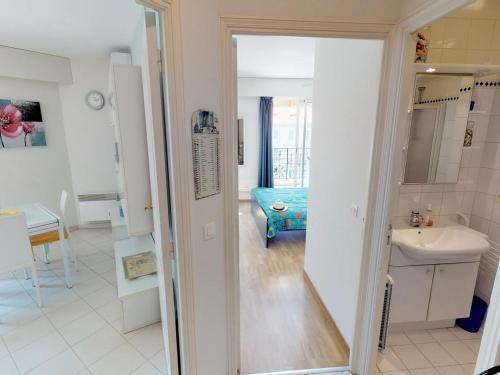 Un baño blanco con lavabo y espejo. en Coquet 2P avec 2 balcons, clim, parking et Wi-Fi gratuit, en plein centre de Menton - FR-1-196-157, en Menton