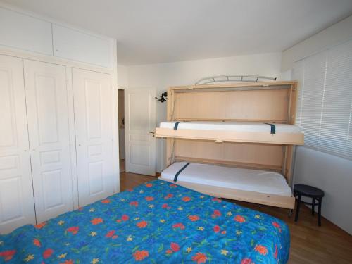 Un dormitorio con una litera con una colcha azul. en Coquet 2P avec 2 balcons, clim, parking et Wi-Fi gratuit, en plein centre de Menton - FR-1-196-157, en Menton