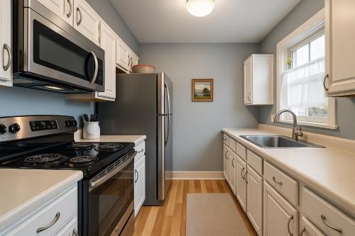 a kitchen with a black refrigerator and a sink at Mountainside Condo King Bed, Two Hot Tubs, Fireplace, Pool , on the Free Bus Route in Steamboat Springs