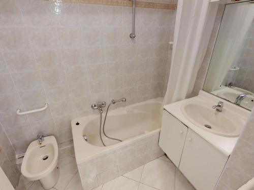 a bathroom with a toilet and a tub and a sink at Grand 2P climatisé, terrasse, parking, centre Menton, commerces & plages à pied - FR-1-196-189 in Menton