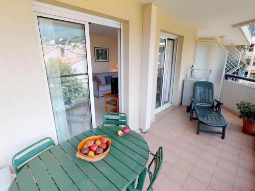 - une table verte avec un bol de fruits sur le balcon dans l'établissement Grand 2P climatisé, terrasse, parking, centre Menton, commerces & plages à pied - FR-1-196-189, à Menton