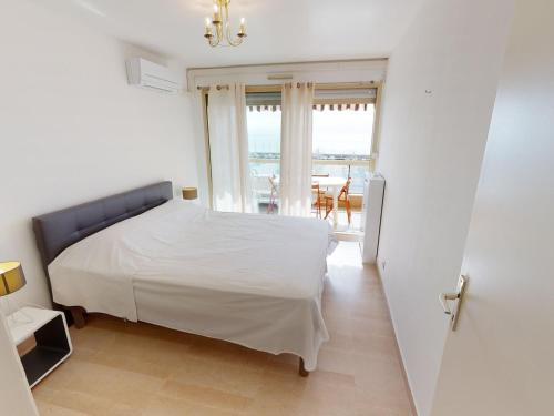 - une chambre avec un lit blanc et un balcon dans l'établissement Magnifique 2P climatisé avec terrasse, garage et wifi gratuit - FR-1-196-196, à Menton