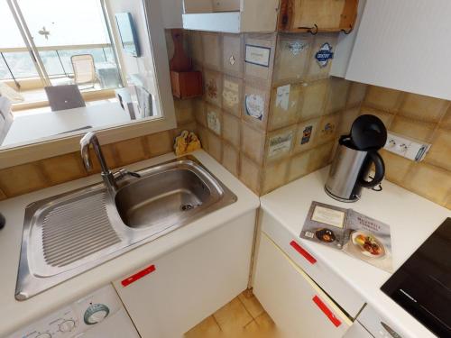 une petite cuisine avec un évier et une fenêtre dans l'établissement Magnifique 2P climatisé avec terrasse, garage et wifi gratuit - FR-1-196-196, à Menton
