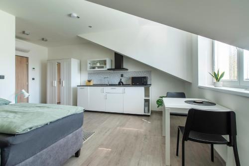 a bedroom with a bed and a table and a kitchen at Restaurace Hotel Praha in Nižbor