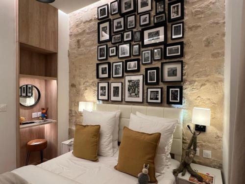 - une chambre avec un mur de photos au-dessus d'un lit dans l'établissement Appartement 2 pièces Rue de la voûte - Bail mobilité, à Paris