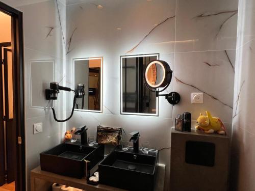 une salle de bain avec deux lavabos et un miroir dans l'établissement Appartement 2 pièces Rue de la voûte - Bail mobilité, à Paris