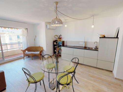 une cuisine et une salle à manger avec une table et des chaises en verre dans l'établissement Beau 3P rénové avec terrasse, parking privé et climatisation - FR-1-196-267, à Menton