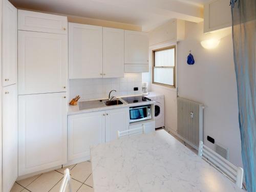 une cuisine blanche avec un évier et un micro-ondes dans l'établissement Charmant 2P avec terrasse, garage privé, proche centre et plages de Menton - FR-1-196-210, à Menton