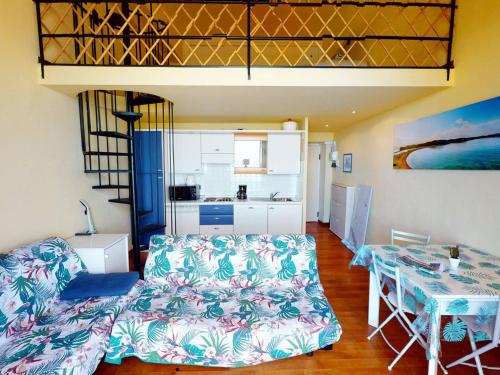 un salon avec un lit et une table et une cuisine dans l'établissement Joli studio mezzanine, proche plages, Wifi et animaux admis - FR-1-196-289, à Menton