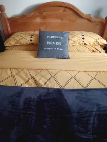 a bed with a blue pillow on top of it at Gite Les Volets Bleus du Segur in Le Ségur-Suech