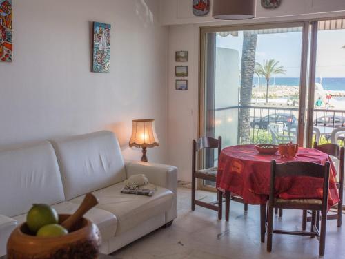 un salon avec un canapé et une table avec un tissu de table rouge dans l'établissement Studio moderne avec terrasse proche plages et centre, WiFi gratuit - FR-1-196-216, à Menton