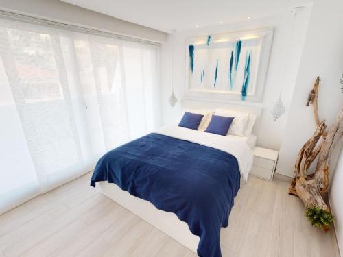 une chambre avec un lit avec des draps bleus et blancs dans l'établissement Superbe 3P climatisé avec grande terrasse et parking - FR-1-196-290, à Menton