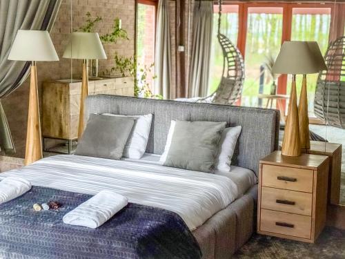 a bed in a room with two lamps and a table at Sala Resort Plateliai & SPA in Plateliai