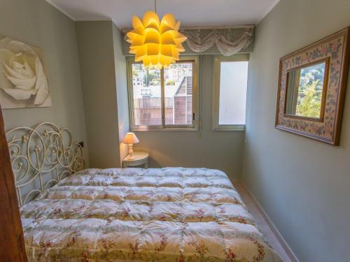 une chambre avec un lit, une fenêtre et un lustre dans l'établissement Charmant 2P avec terrasse, proche des plages et du centre de Menton - FR-1-196-160, à Menton