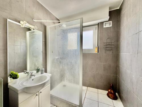 a white bathroom with a sink and a shower at Bretzel in Colmar
