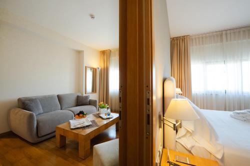 a hotel room with a bed and a couch at Hotel Touring in Carpi