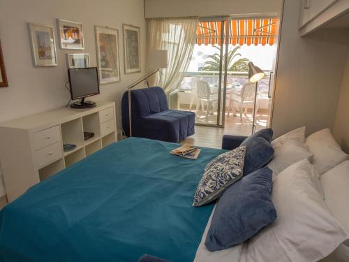 a bedroom with a bed with pillows and a television at Studio rénové face mer avec terrasse, clim, wifi et proche commodités à Menton - FR-1-196-167 in Menton