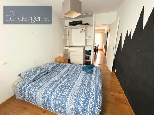une chambre avec un lit avec une couette bleue dans l'établissement Le Belvédère #28-La Conciergerie - Poitiers centre, à Poitiers