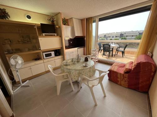 une cuisine et un salon avec une table et des chaises dans l'établissement Studio cabine CAP D'AGDE NATURISME CN060-K118, au Cap d'Agde