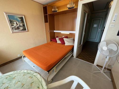 - une petite chambre avec un lit et une couverture orange dans l'établissement Studio cabine CAP D'AGDE NATURISME CN060-K118, au Cap d'Agde