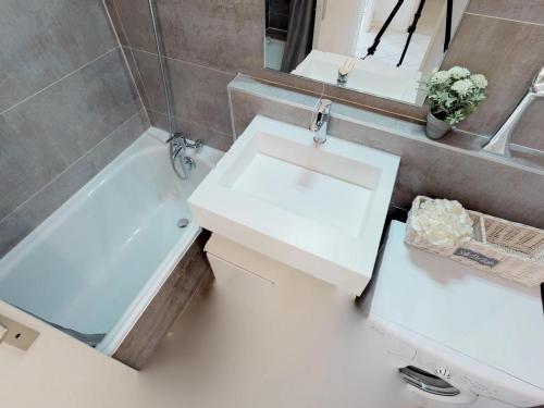 une salle de bain avec un lavabo blanc et une baignoire dans l'établissement Grand 2P avec Parking et Terrasse, Piscine sur le Toit, Proche des Plages à Menton - FR-1-196-172, à Menton