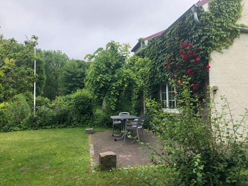 a picnic table in a garden next to a house at große Ferienwohnung Inselhuus in Nordstrand