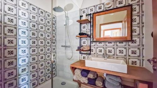 une salle de bain avec un lavabo et un miroir dans l'établissement Mas de la Plaine, à Marsillargues