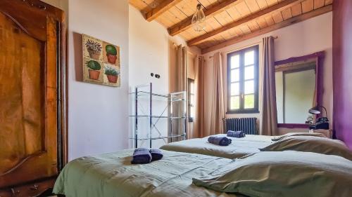 Ce lit se trouve dans un dortoir doté de murs violets et d'une fenêtre. dans l'établissement Mas de la Plaine, à Marsillargues